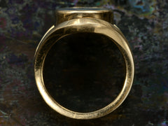 thumbnail of Side profile view of a vintage French yellow gold signet ring with the image of a fish jumping through a lozenge shape carved into blue and black chalcedony. Shown on dark background.