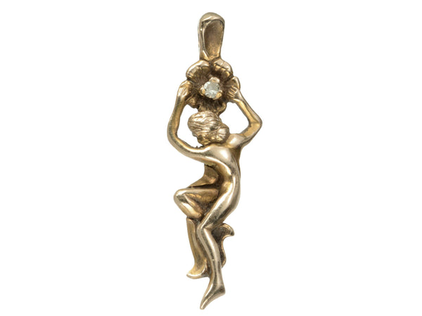 Gold vintage pendant in the form of a a woman hanging from a flower (shown on white background)
