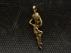 thumbnail of Reverse side of vintage pendant in the form of a a woman hanging from a flower (shown on dark textured background)