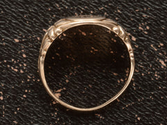 thumbnail of Side profile view of antique rose gold Art Nouveau signet ring with lily designs, shown on dark background. 