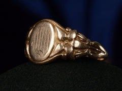 thumbnail of Angled view of antique rose gold Art Nouveau signet ring with lily designs, shown on dark background. 