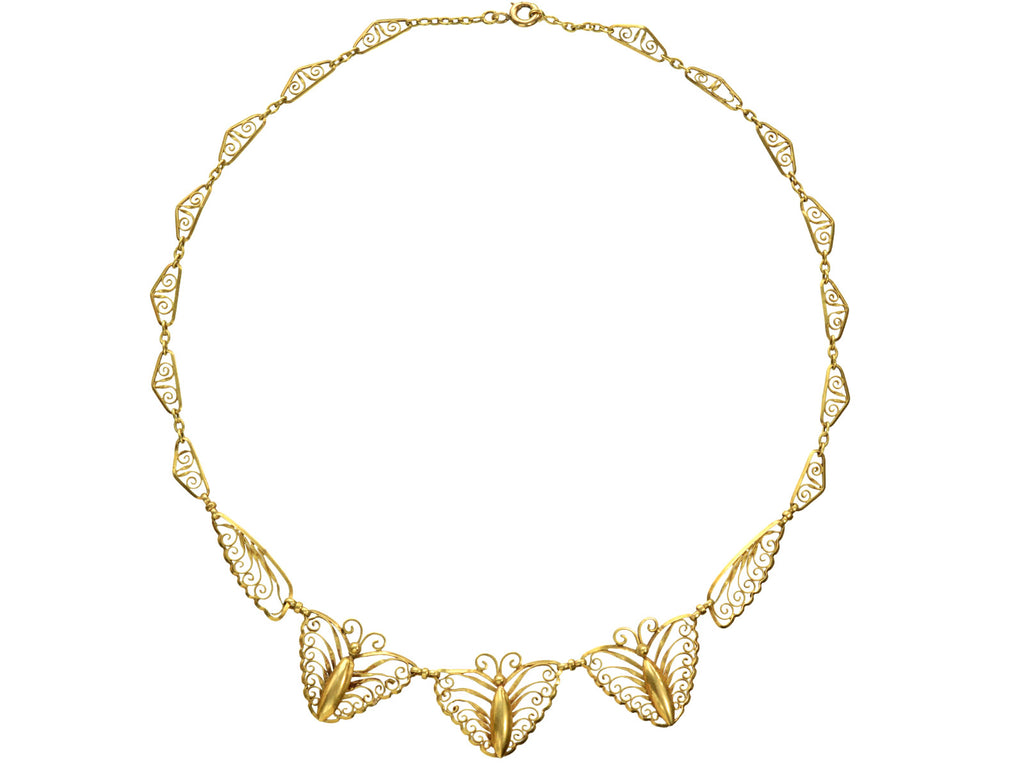 An antique French gold filigree necklace featuring three large butterfly motifs at the front, suspended from a delicate linked chain with small leaf-like elements, shown on a plain white background.