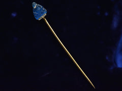 thumbnail of French stick pin with blue glass Buddha decorated with diamonds in platinum and yellow gold, shown on dark background.