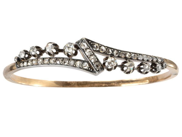 An antique French silver topped yellow gold bracelet with a zig-zag of rose cut diamonds, shown on white background.