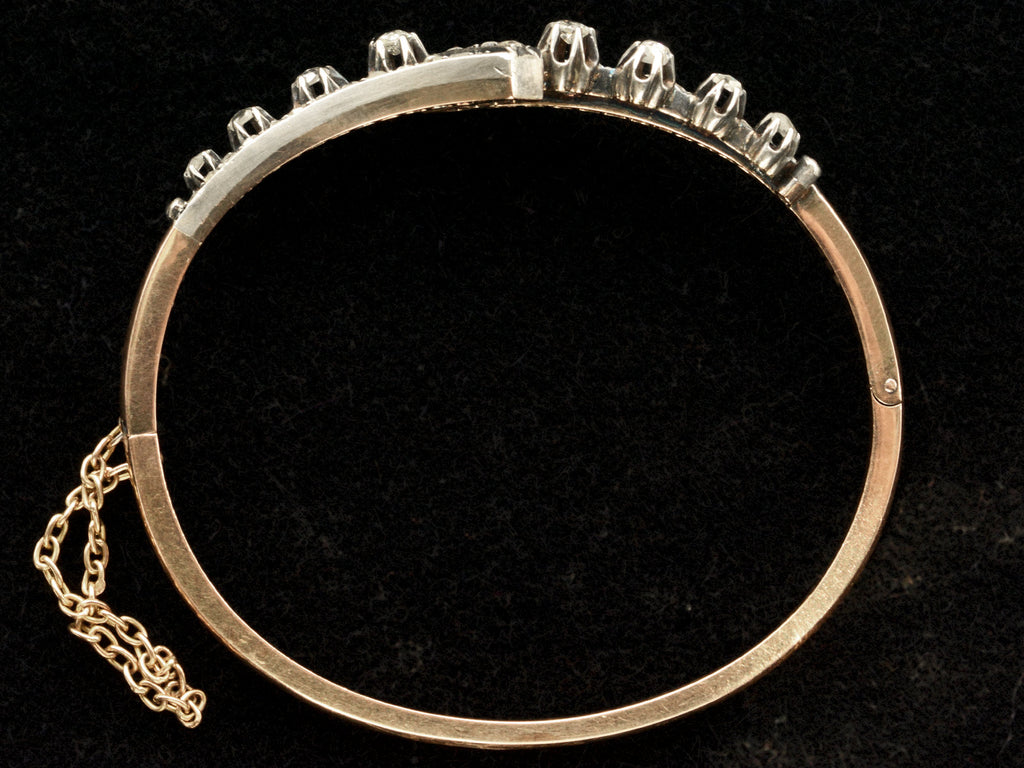 Side profile of an antique French silver topped yellow gold bracelet with a zig-zag of rose cut diamonds, shown on black background.