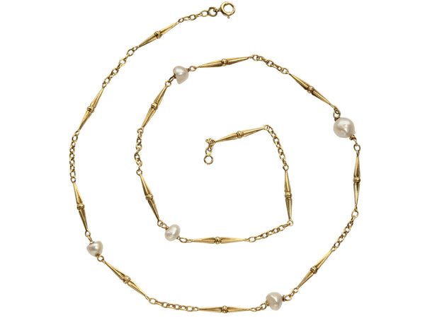 Detail of c1920 French Art Deco gold chain necklace with interspersed pearls, shown spiraled on white background