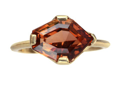 thumbnail of Face on view of shield shaped orangey red stone set in 18K yellow gold, on white background.