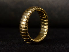 thumbnail of Angled view of flexible gaspipe-link 18k yellow gold band, shown on dark background.
