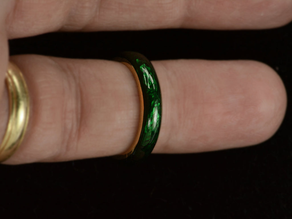 A heavy vintage 18K yellow gold rounded band with dark green enamel, shown on finger.