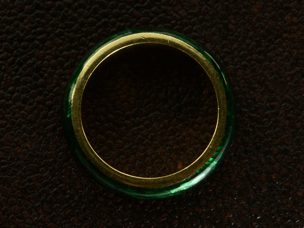 Side profile of heavy vintage 18K yellow gold rounded band with dark green enamel, shown on dark textured background.