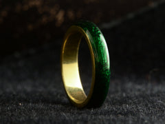thumbnail of Angled view of heavy vintage 18K yellow gold rounded band with dark green enamel, shown on dark background.