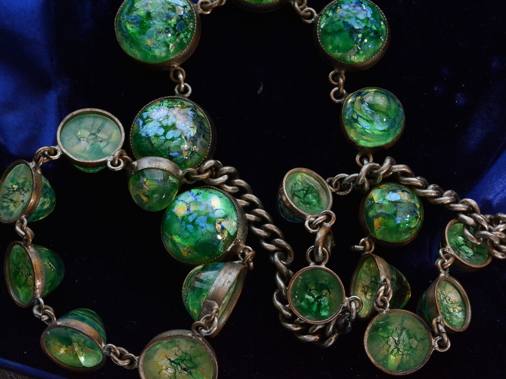 c1930 Iridescent Green Necklace (detail of glass on dark blue background)