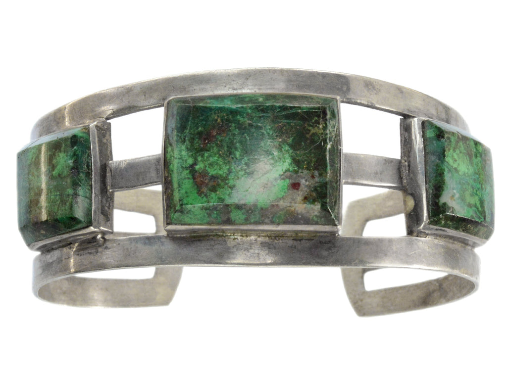 A silver cuff bracelet featuring three rectangular green malachite stone inlays, set against a plain white background.