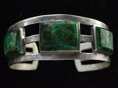 thumbnail of A sterling silver cuff bracelet featuring three rectangular green stone inlays with natural matrix patterns, set against a solid black background.