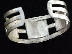 thumbnail of Inside of a vintage sterling silver cuff, showing stamps depicting an eagle, and "925" and "TAXCO." On black background.