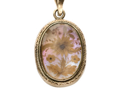 thumbnail of Victorian gold mourning pendant with blond hair arrange in a floral design on iridescent mother of pearl, shown on white background.