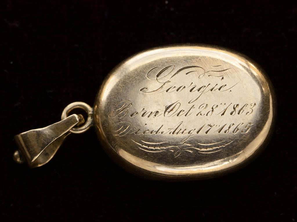 Reverse side of locket with engraved text "Georgies Born Oct 28 1863 Died Aug 17 1865" On black background.