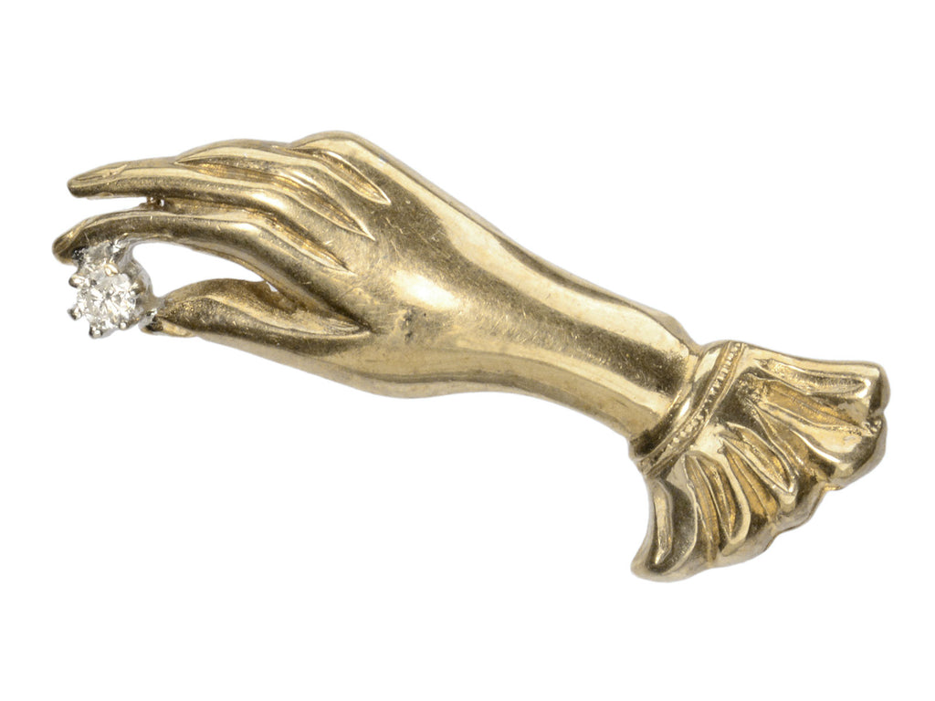 c1950 Brooch in the form of a yellow gold hand holding a white diamond (shown on white background)