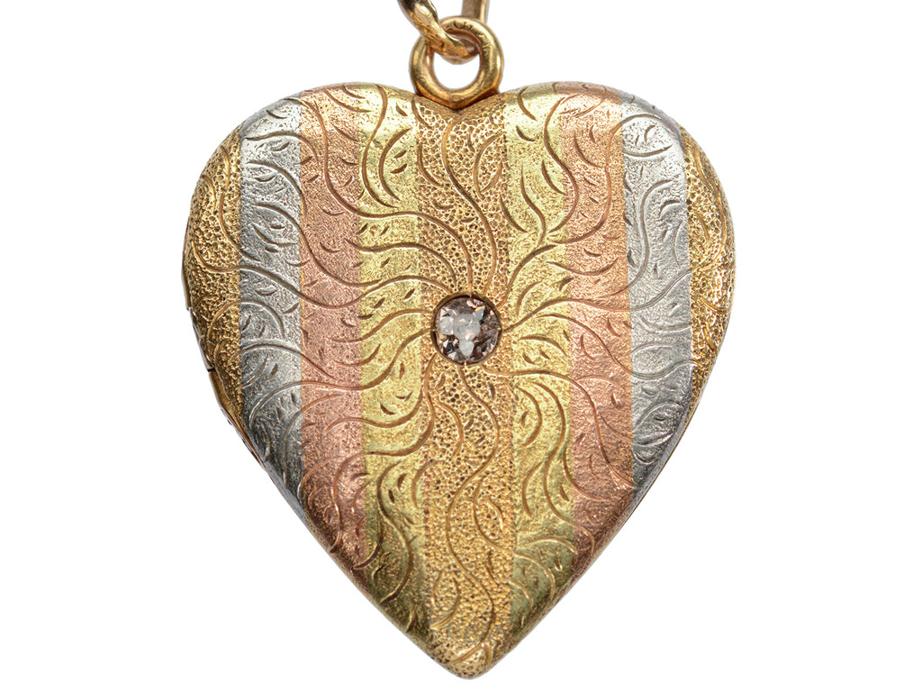 c1900 Heart Locket in yellow gold with stripes of platinum and rose gold and a pink diamond center, shown on white background