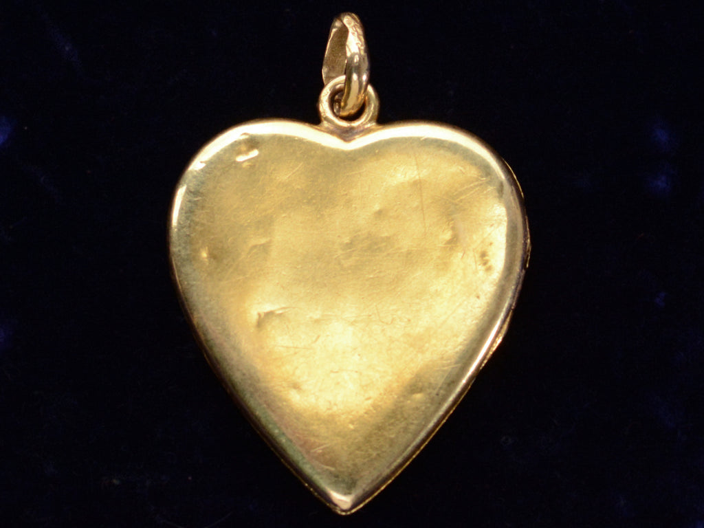 Reverse side of c1900 Heart Locket in yellow gold with stripes of platinum and rose gold and a pink diamond center, showing small dents.