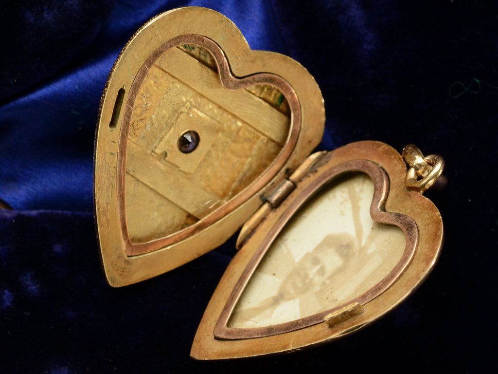 c1900 Heart Locket in yellow gold with stripes of platinum and rose gold and a pink diamond center, shown open