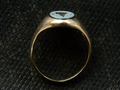 thumbnail of Side profile of an antique yellow gold signet ring with an oval black and blue chalcedony intaglio shown on dark textured background.