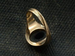thumbnail of Reverse view of antique yellow gold signet ring, showing a twisted shank, shown on dark textured background.