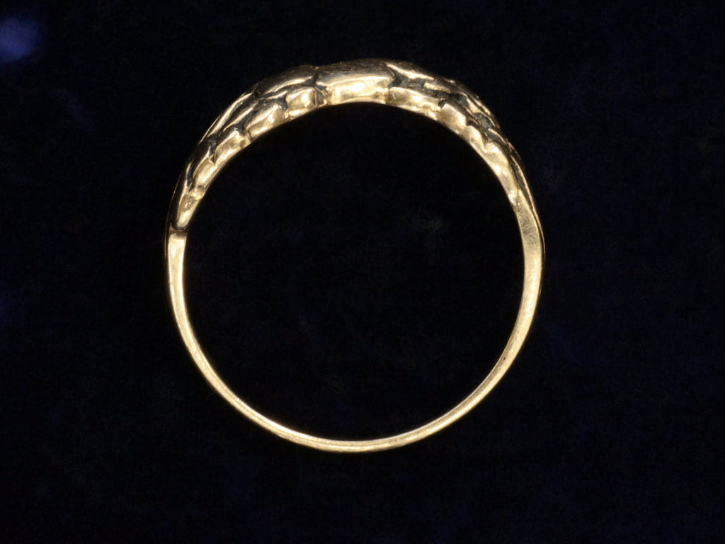 Side profile of vintage gold ring with pair of running horses, shown on dark background.