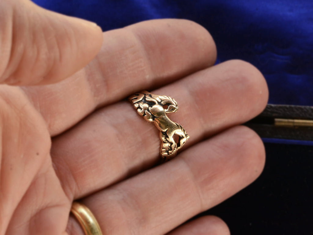 Vintage gold ring with pair of running horses, shown on finger