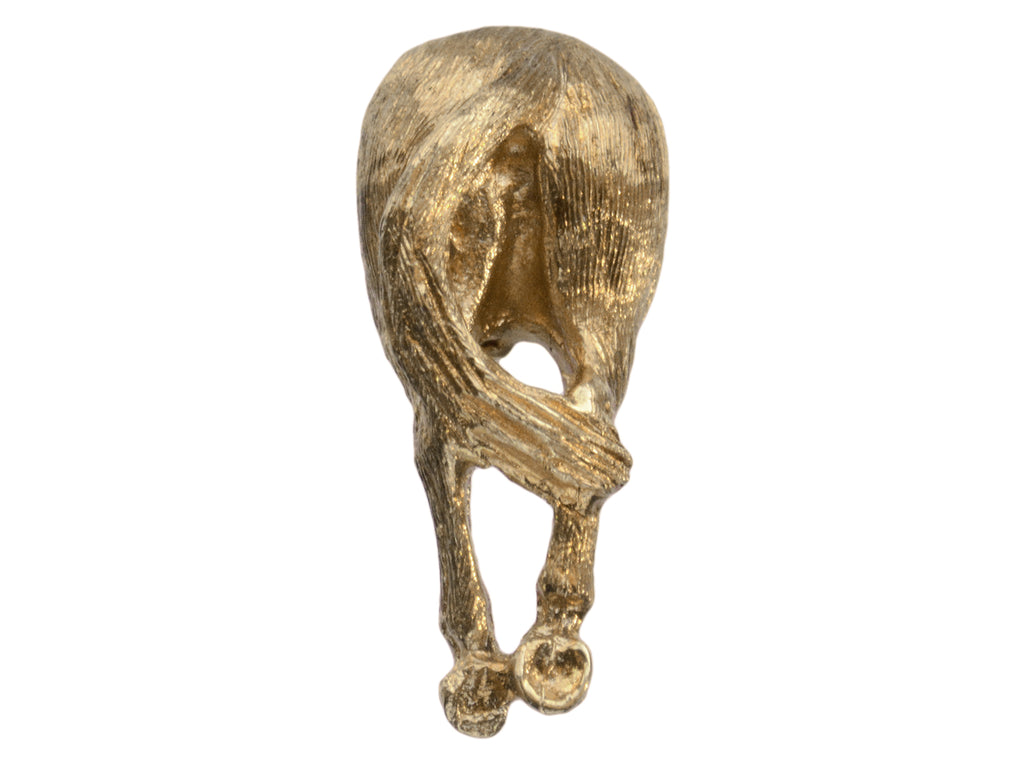 A vintage yellow gold tie tack in the form of a horse's ass. Shown on white background.