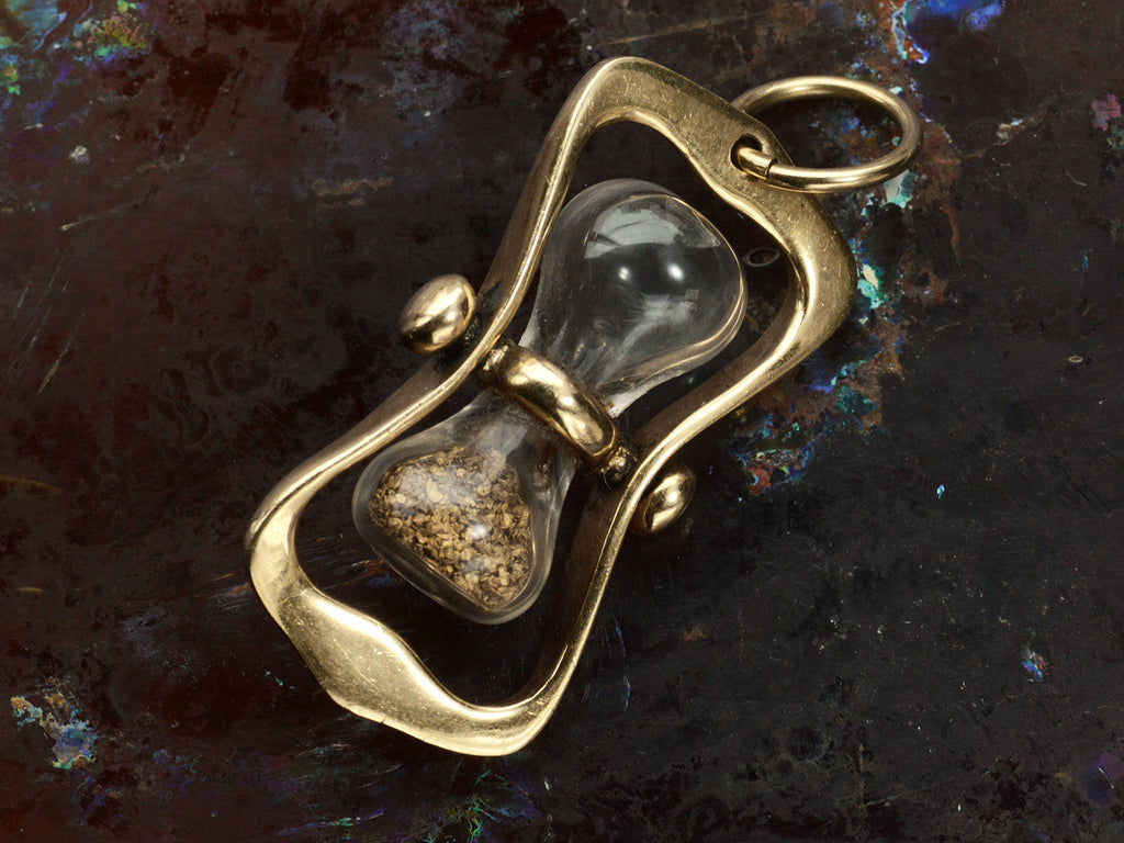 c1970 Yellow Gold Hourglass Pendant with Gold Flakes inside glass (on dark background)