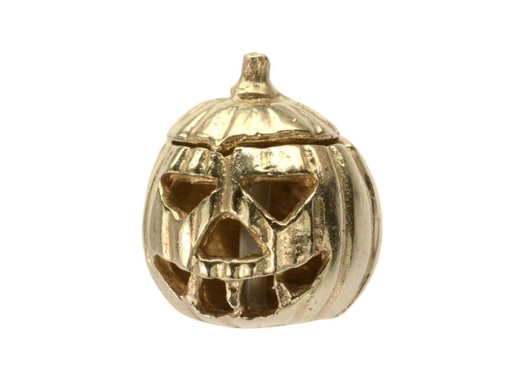 A vintage gold Jack-O'-Lantern charm, on white background.