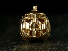 thumbnail of Front view of vintage gold Jack-O'-Lantern charm, on dark background.