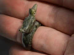 thumbnail of Top view of carved nephite jade figural ring with bird. Shown on finger.