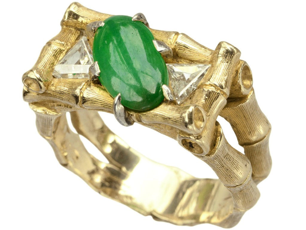 Angled view of a vintage gold, green jade and triangular diamond with a mounting designed to look like bamboo, shown on white background.