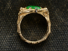 thumbnail of Side profile view of a vintage gold jade and diamond ring with a mounting designed to look like bamboo, shown on dark textured background.