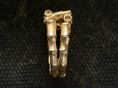 thumbnail of Side view of a vintage gold ring with a mounting designed to look like bamboo, shown on dark textured background.