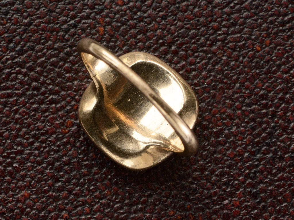 Inside view of an antique signet ring in rosy-yellow gold and shown on dark textured background.