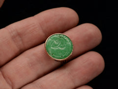 thumbnail of Carved green jade and yellow gold ring on finger.