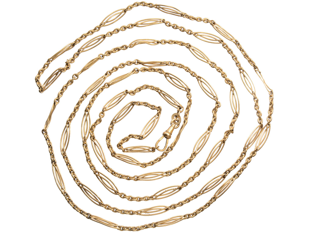 A long filigreed yellow gold plated c1890 chain, shown spiraled on a white background.