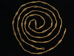 thumbnail of A long filigreed yellow gold plated c1890 chain, shown spiraled on a black background.