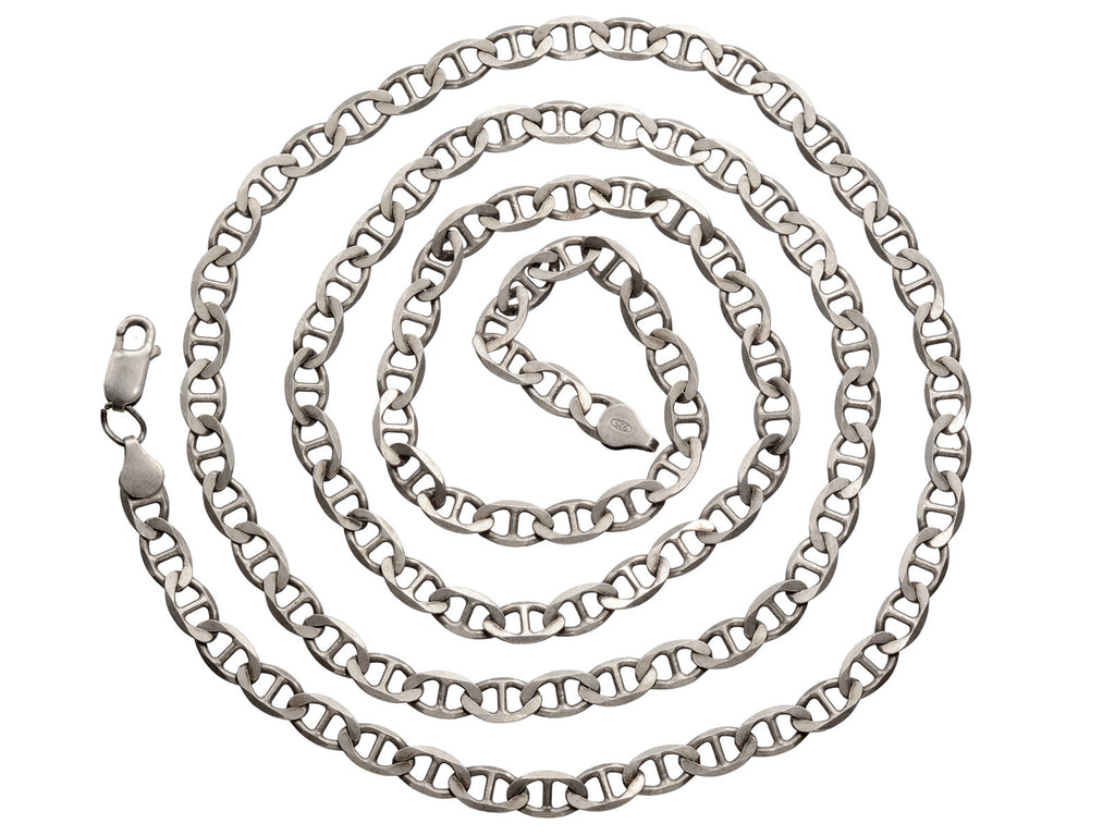 Long mariner style link silver chain shown coiled on white background.