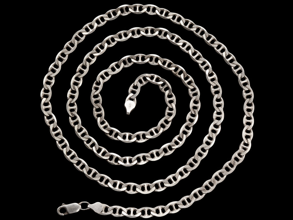Long mariner style link silver chain shown coiled on black background.