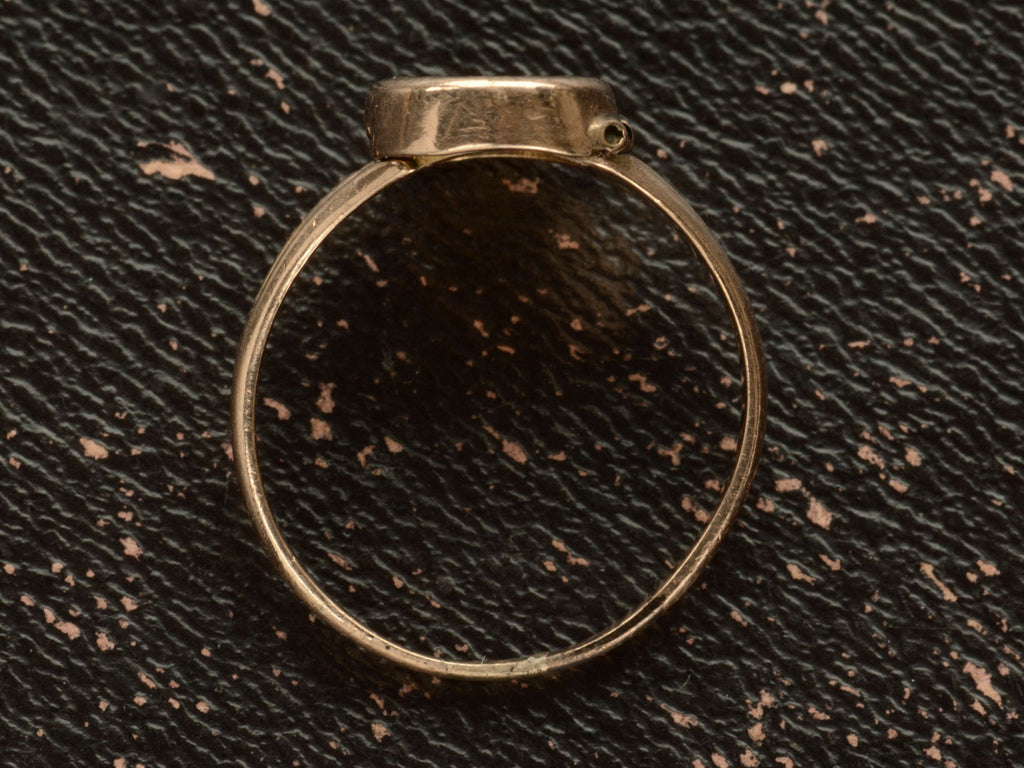 Side profile of a c1920 antique signet ring on dark background.