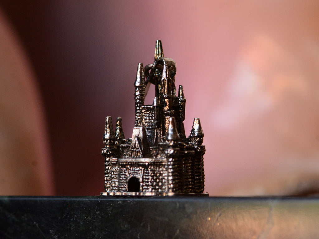 c1990 Silver Disney Castle Charm (side angle profile on pink background) 