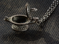thumbnail of Detail of sterling silver magic lantern pendant hanging from cable chain, shown with lid open on dark textured leather background.