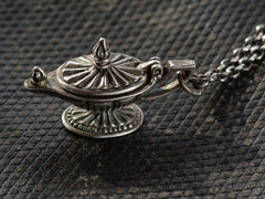 thumbnail of Detail of sterling silver magic lantern pendant hanging from cable chain, shown with lid closed on dark textured leather background.