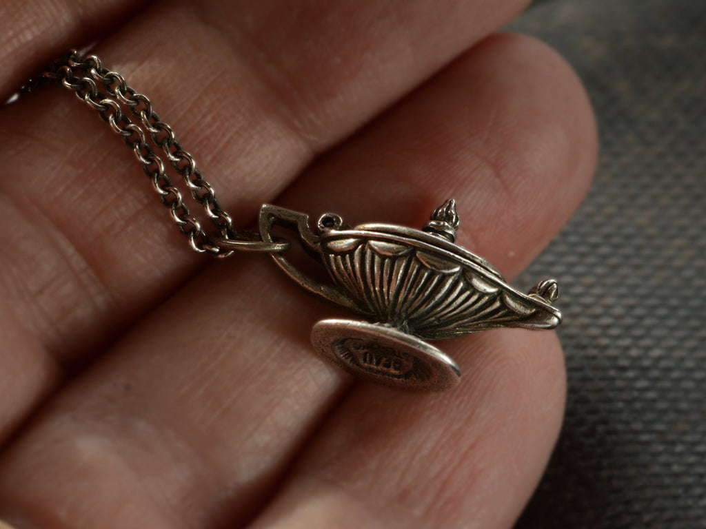 Detail of sterling silver magic lantern pendant hanging from cable chain, shown held in hand. Stamp on bottom reads "BEAU STERLING"