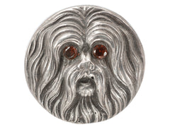 thumbnail of Round silver brooch with the face of a maltese dog with garnet eys, shown on white background.