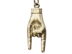 thumbnail of Detail of vintage gold hand pendant gesturing the sign of the horns, on white background.